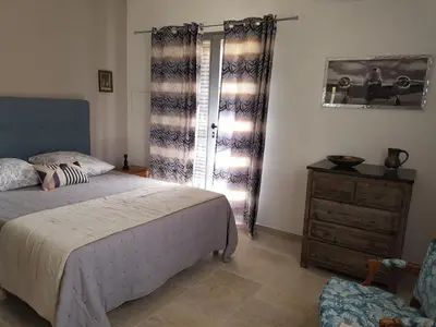 a bedroom with a bed and a dresser and a window at Villa Capraghjese in Galeria
