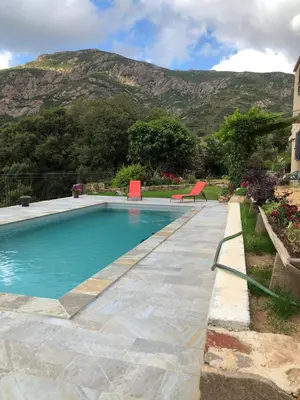 a swimming pool with a mountain in the background at Villa Capraghjese in Galeria