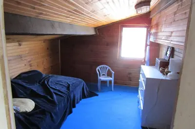 a bedroom with a bunk bed and a chair in a room at Demi villa à 150m de la plage avec vue sur mer in Appietto
