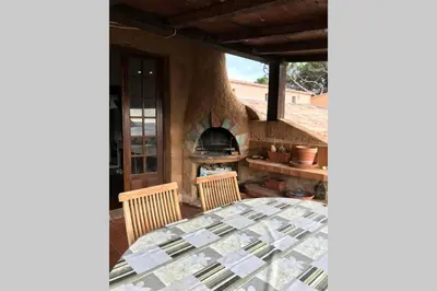 a patio with a table and a fireplace at Demi villa à 150m de la plage avec vue sur mer in Appietto