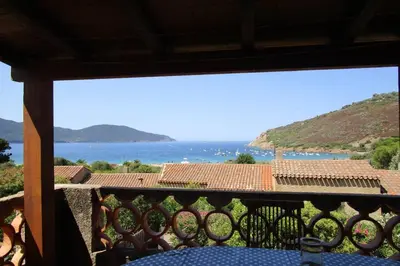 a view of the ocean from a balcony at Demi villa à 150m de la plage avec vue sur mer in Appietto