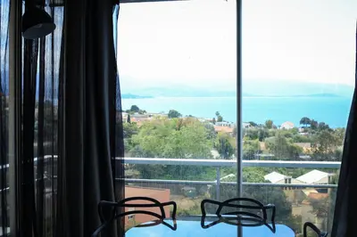 a room with a table and chairs and a large window at Mare e Vista in Ajaccio