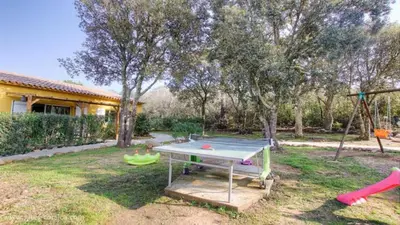 a ping pong table in a yard with a playground at Chez Pierre à Porto-Vecchio in Porto-Vecchio