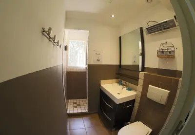 a bathroom with a sink and a toilet and a mirror at Chez Pierre à Porto-Vecchio in Porto-Vecchio
