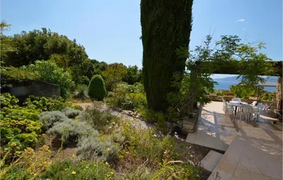 a garden with a table and chairs on a patio at Lovely Home In Porticcio With Wifi in Porticcio