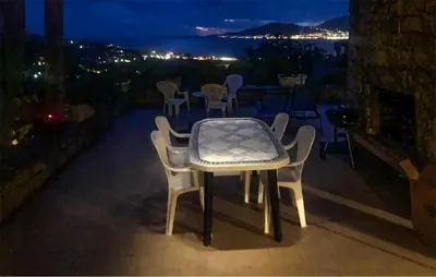 a table and chairs on a balcony at night at Lovely Home In Porticcio With Wifi in Porticcio