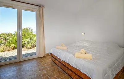 a bedroom with a bed with two towels on it at Lovely Home In Porticcio With Wifi in Porticcio