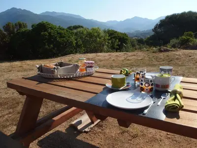 a picnic table with a meal on top of a field at PROPRIANO in Propriano