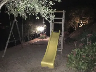 a yellow slide in a garden at night at PROPRIANO in Propriano