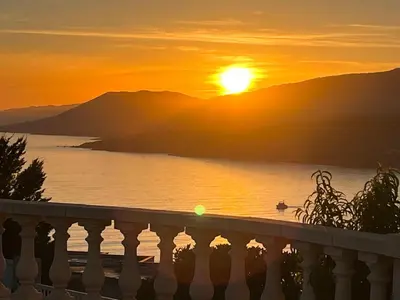 a sunset over the water with mountains in the background at PROPRIANO in Propriano