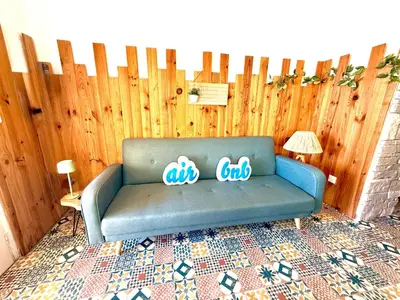 a blue couch in front of a wooden fence at 