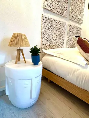 a table with a lamp on it next to a bed at 