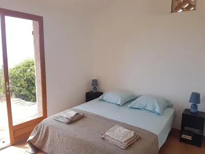 a bedroom with a bed with two towels on it at Maison sur Palombaggia in Porto-Vecchio