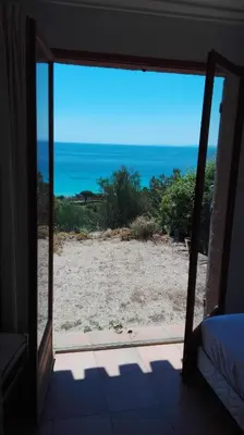 a view of the ocean from a bedroom window at Maison sur Palombaggia in Porto-Vecchio