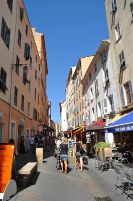 a group of people walking down a street with buildings at Studio terrasse rue piétonne Ajaccio in Ajaccio