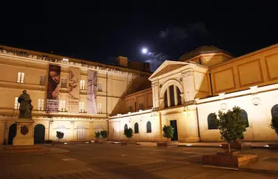 a building at night with a moon in the sky at Studio terrasse rue piétonne Ajaccio in Ajaccio