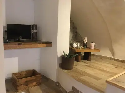 a living room with a tv and a wooden floor at Casa LiLi in Castello-di-Rostino