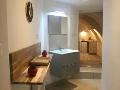 a bathroom with a sink and a hallway with an arch at Casa LiLi in Castello-di-Rostino