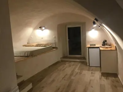 a room with a bed and a kitchen with a table at Casa LiLi in Castello-di-Rostino