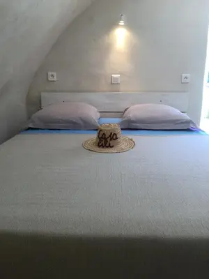 a bed with a hat on it with two pillows at Casa LiLi in Castello-di-Rostino