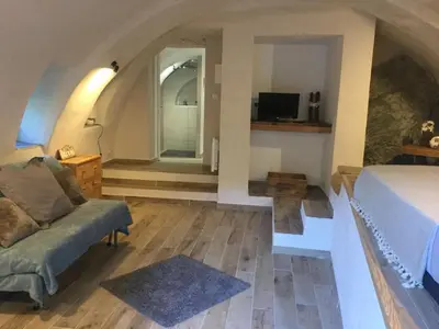 a bedroom with a bed and a couch and a window at Casa LiLi in Castello-di-Rostino