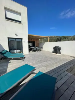 a deck with blue lounge chairs and a television at MAISON NEUVE PORTO VECCHIO in Porto-Vecchio