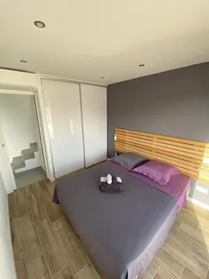a bedroom with a large bed with a stuffed animal on it at MAISON NEUVE PORTO VECCHIO in Porto-Vecchio