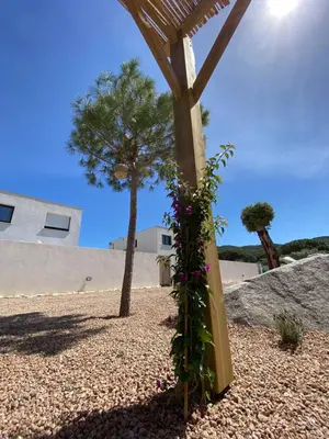 a wooden pole with flowers on it on a beach at MAISON NEUVE PORTO VECCHIO in Porto-Vecchio