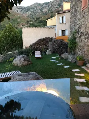 a view of a garden with a bench and a building at 1722 Chambres de Charme in Ville-di-Paraso