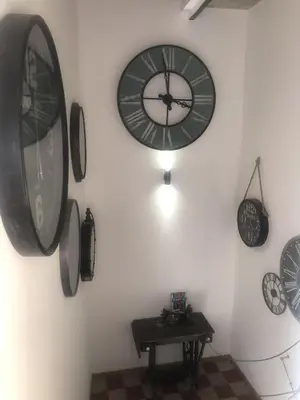a room with clocks on the wall and a table at 1722 Chambres de Charme in Ville-di-Paraso