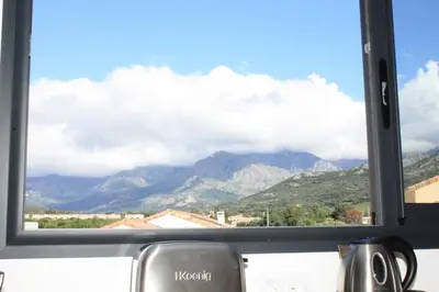 a window with a view of a mountain range at T2 Loft entre mer et montagne in Calenzana