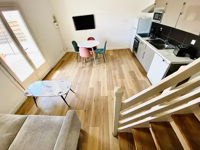 a kitchen and a living room with a table and chairs at Propriété Malva appartement bergamotta in Alata