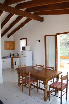 a kitchen with a wooden table and two chairs at Gîtes à COZZANO in Cozzano