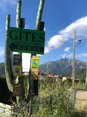 a sign for a cafe with mountains in the background at Gîtes à COZZANO in Cozzano