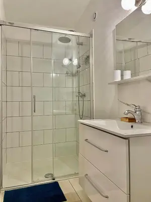 a bathroom with a glass shower and a sink at Appartement F2 Duplex in Sartène