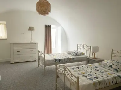 a bedroom with two beds and a dresser at Appartement F2 Duplex in Sartène