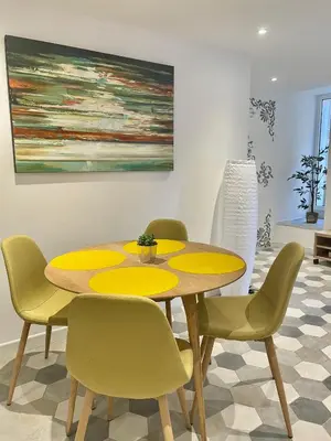 a dining room with a yellow table and chairs at Appartement F2 Duplex in Sartène