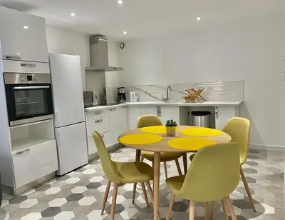 a kitchen with a table and chairs in a kitchen at Appartement F2 Duplex in Sartène