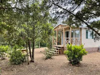 a small house with a porch and trees at Palombaggia location i pini Porto Vecchio in Porto-Vecchio