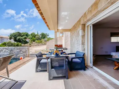 a patio with a table and chairs on a deck at Holiday Home Villa Belios by Interhome in Porto-Vecchio