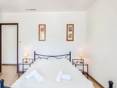 a bedroom with a white bed with two night stands at Holiday Home Villa Belios by Interhome in Porto-Vecchio