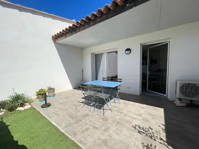 a patio with a blue table and chairs at Mini villa K2 in Bonifacio