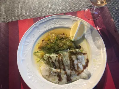 a white plate with food on a table at Chambres et tables d'hôtes Zélia & Jacques BERQUEZ in Pianottoli-Caldarello