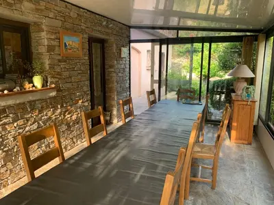 a dining room with chairs and a stone wall at Chambres et tables d'hôtes Zélia & Jacques BERQUEZ in Pianottoli-Caldarello