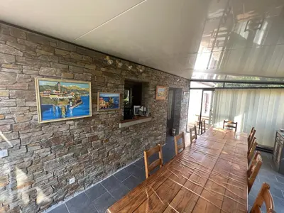 a room with a stone wall with a wooden table and chairs at Chambres et tables d'hôtes Zélia & Jacques BERQUEZ in Pianottoli-Caldarello