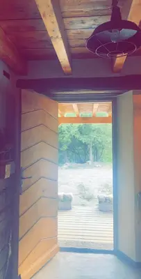 a sliding glass door in a room with a wooden wall at La bergerie du Chêne in Omessa