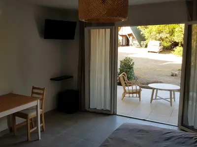 a bedroom with blue walls and a bed and a table at les terrasses d'arutoli in Porto-Vecchio