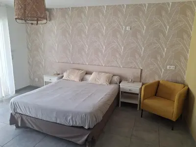 a bedroom with a bed and a blue chair at les terrasses d'arutoli in Porto-Vecchio