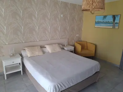 a bedroom with a white bed and a table at les terrasses d'arutoli in Porto-Vecchio