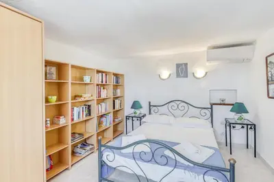 a bedroom with a bed and book shelves at EL ORO - Terrasse Vue Mer et piscine - Porto Vecchio in Porto-Vecchio